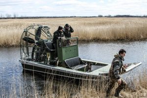 Adam Smith, right, helps at a marsh cleanup with the Michigan DNR. Smith says Ducks Unlimited is an amazing way for nature-lovers to volunteer their time. Photo credit: Ducks Unlimited