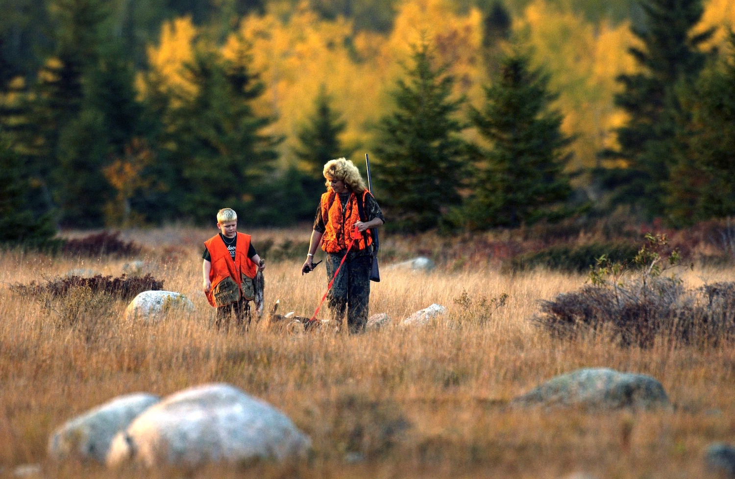 Mother and son stand in field while upland game hunting