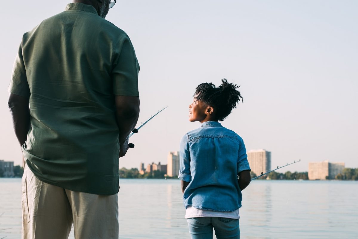 A man and a Young kid fishing on the lake